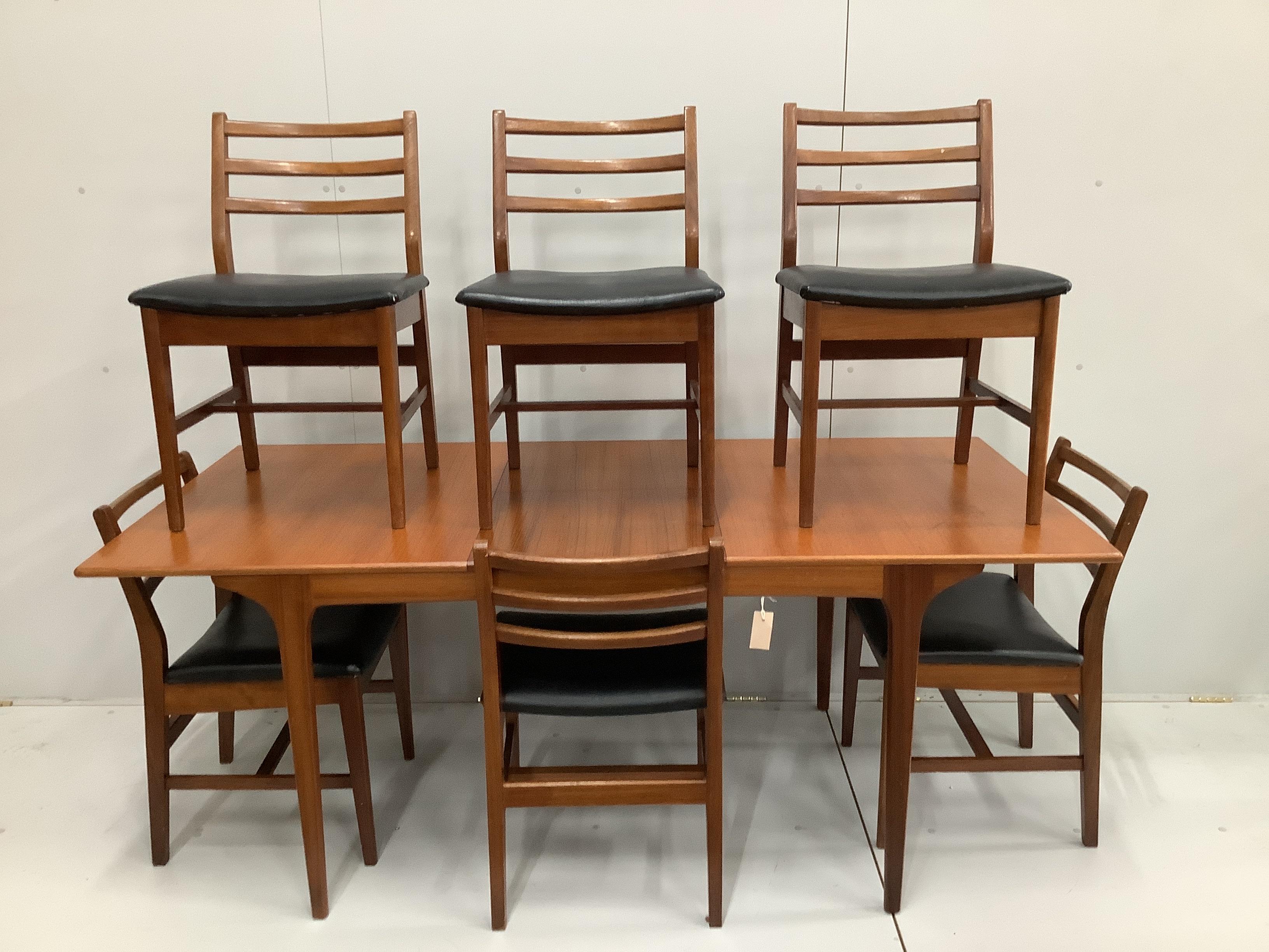 A mid century Danish design teak extending dining table, 184cm extended, width 86cm, height 73cm and six chairs with black leatherette seats